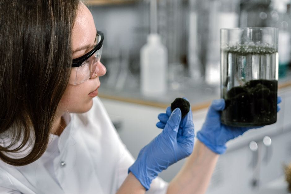Technik laboratoryjny w profesjonalnym ośrodku analizuje próbkę masy asfaltowej w celu potwierdzenia parametrów technicznych